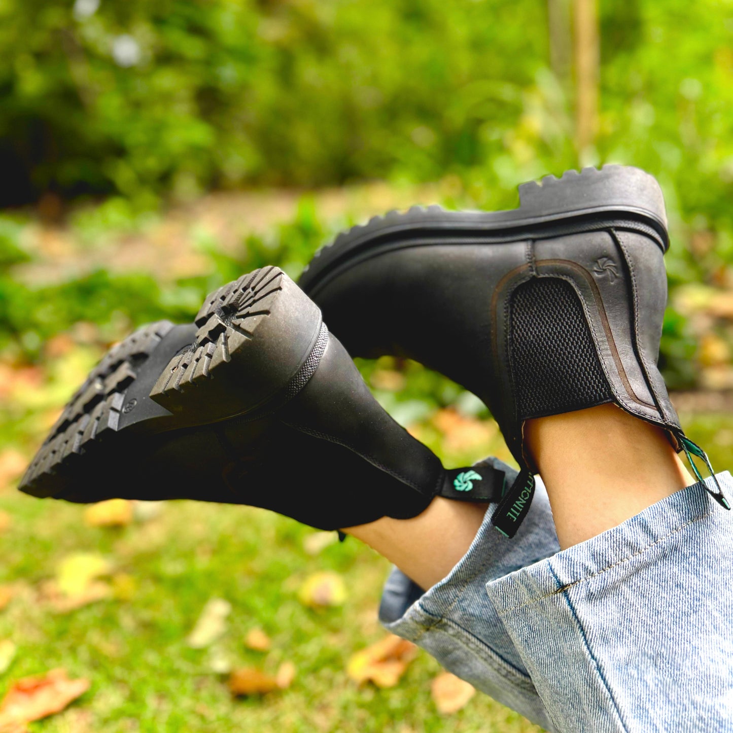 Black Chelsea boots for women worn with a blurred natural background